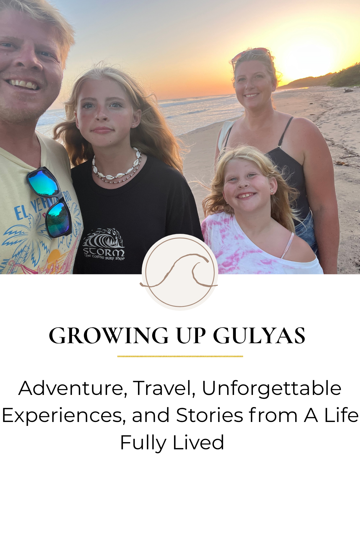 A family of four standing on a beach during sunset. The group includes a man, a woman, and two young girls, all smiling and dressed casually. The background features the ocean, a sandy shoreline, and a bright setting sun.