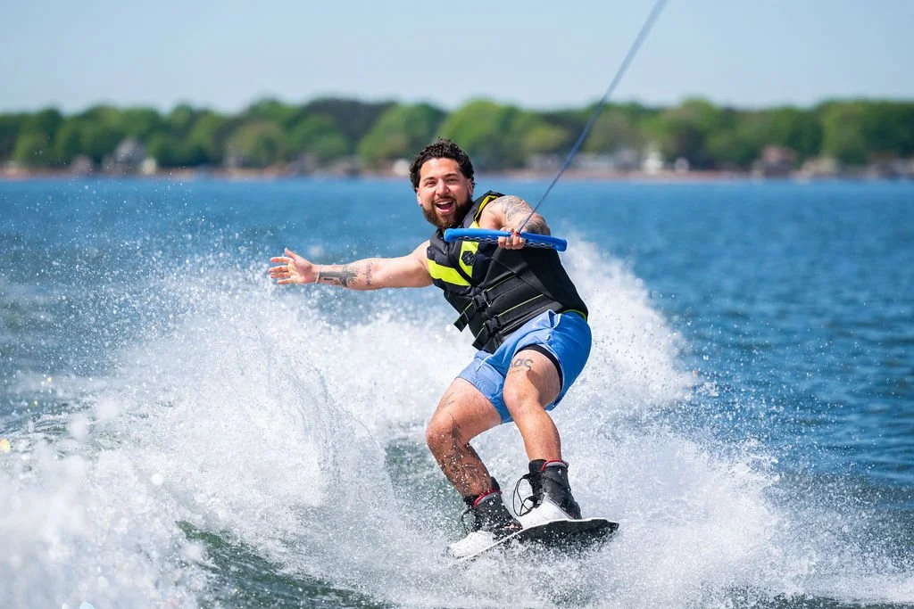 Young man wakeboarding and smiling on Lake Norman, NC.