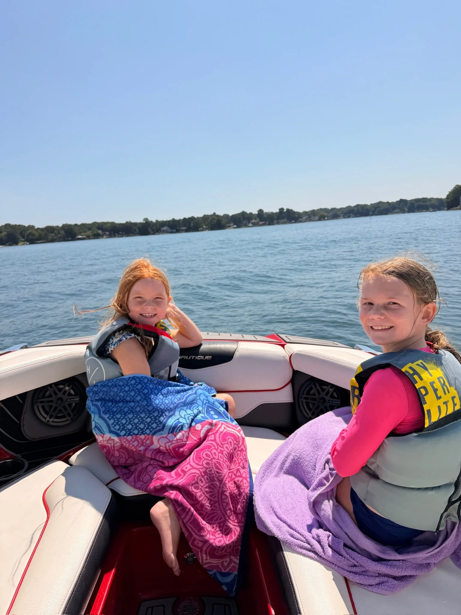 Two young girl riding on a ski boat on lake Norman