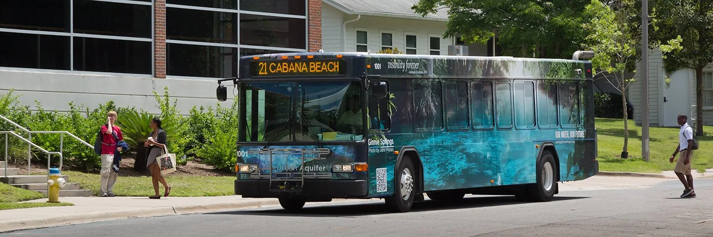 City bus featuring Ginnie Springs artwork and aquifer imagery, part of the Urban Aquifer public art campaign.