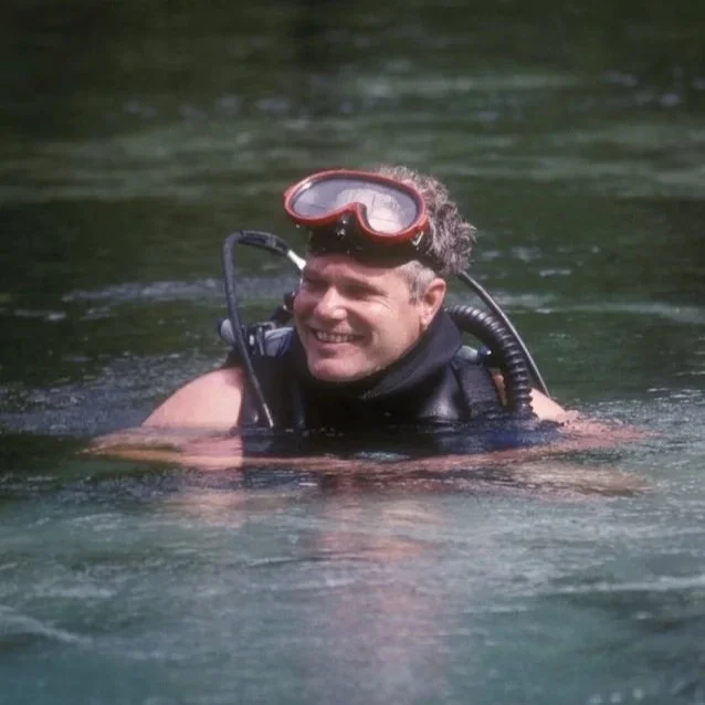 Moderator Tom Morris in scuba gear floating at the water’s surface wearing mask and gear