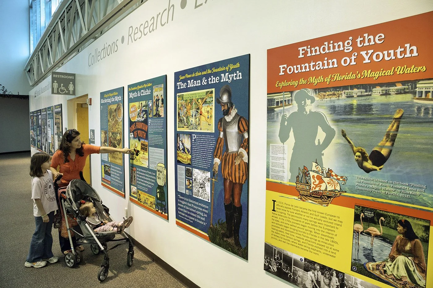 Visitors view panels from the “Finding the Fountain of Youth” exhibition by Rick Kilby, exploring the myths and history of Florida’s magical waters.