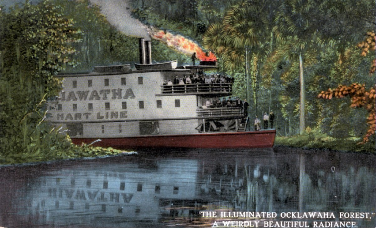 Color illustration of a steamboat labeled “Hiawatha Chart Line” moving along a calm river through lush forest, with smoke rising from the stack and passengers gathered on deck.