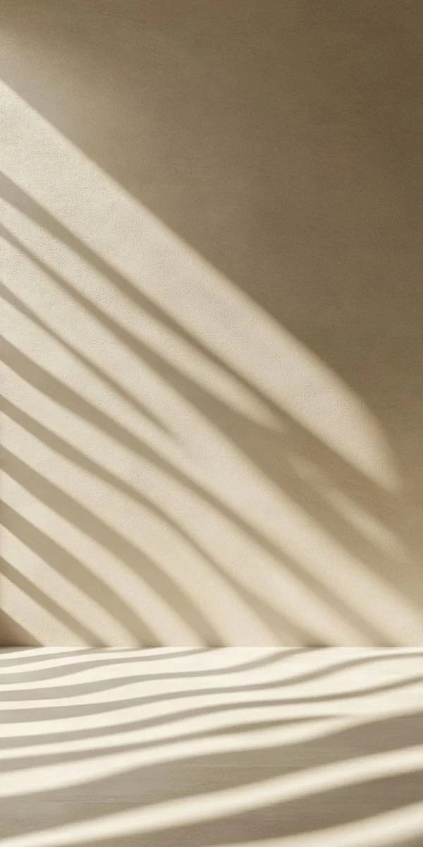 Sunlight streaming through window blinds, casting striped shadows on a beige wall and surface.