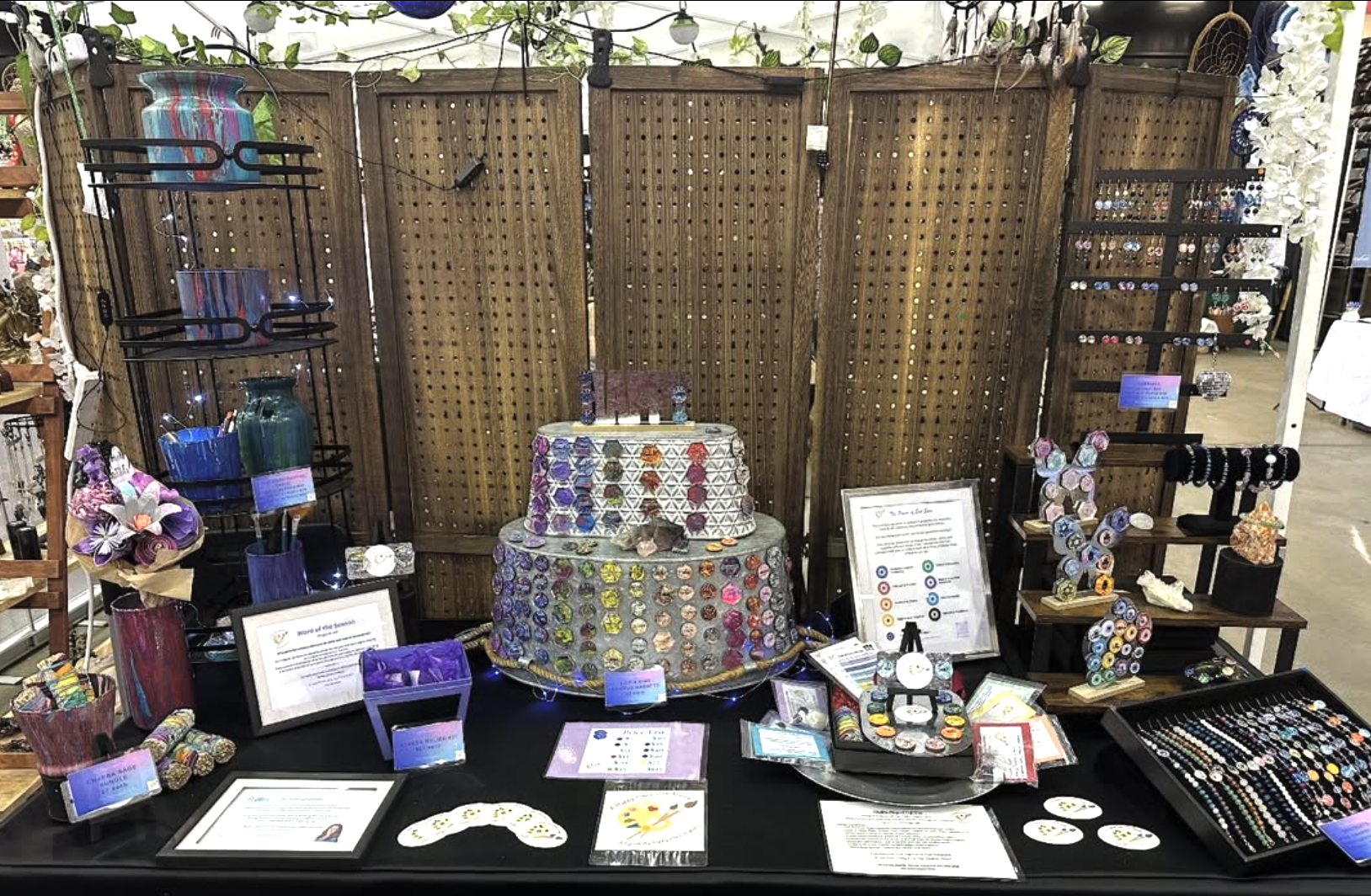 display of magnets and other happy place with nancy products on a table at an artisan market