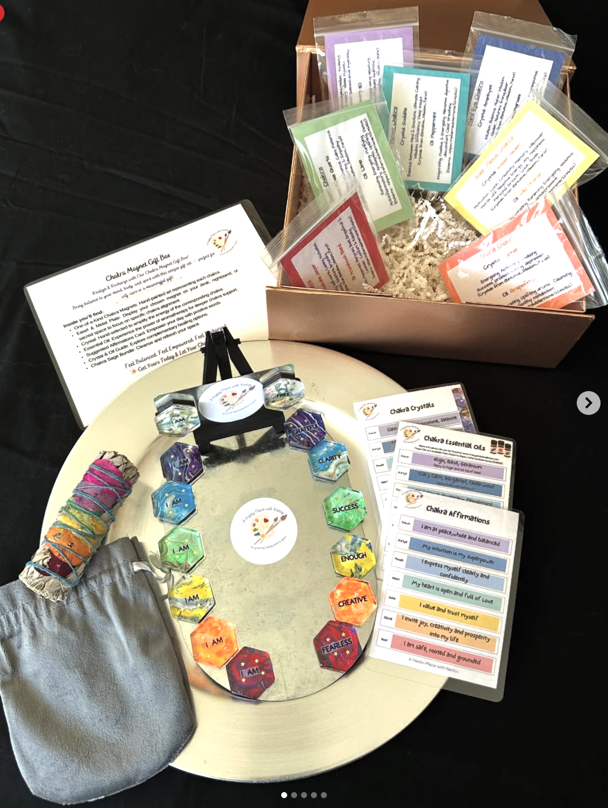display of chakra themed magnets on a gold magnet sitting wiht sage bundle and packages explaining the product