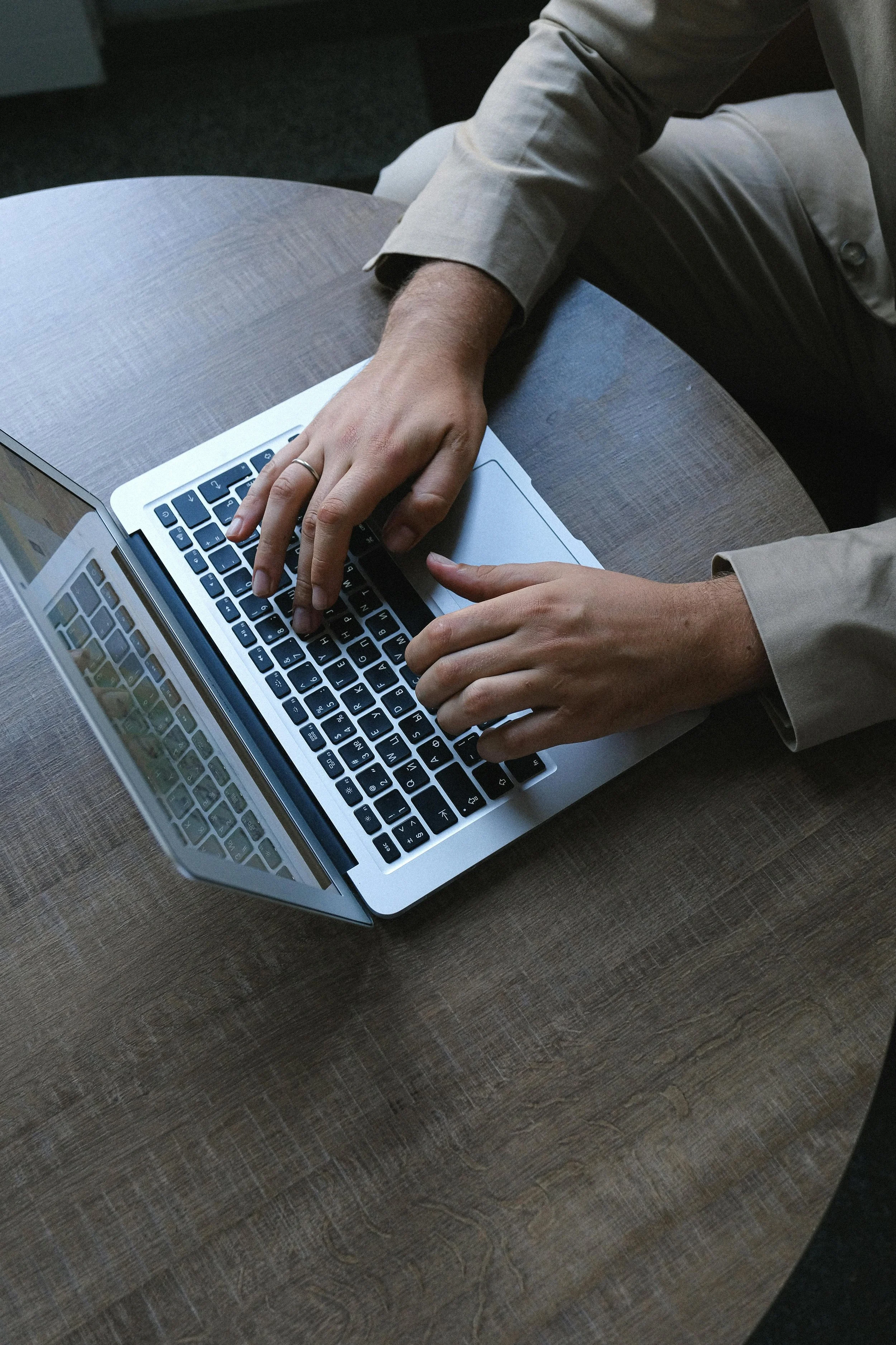 Person sitting at a table using a laptop computer.