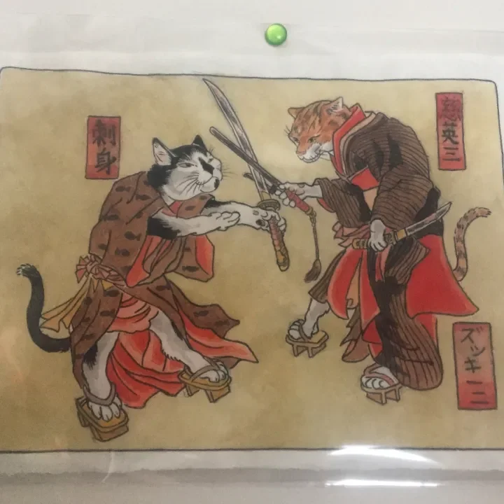 An illustration of two cats dressed as samurai engaging in a sword fight, wearing traditional clothing and armor.