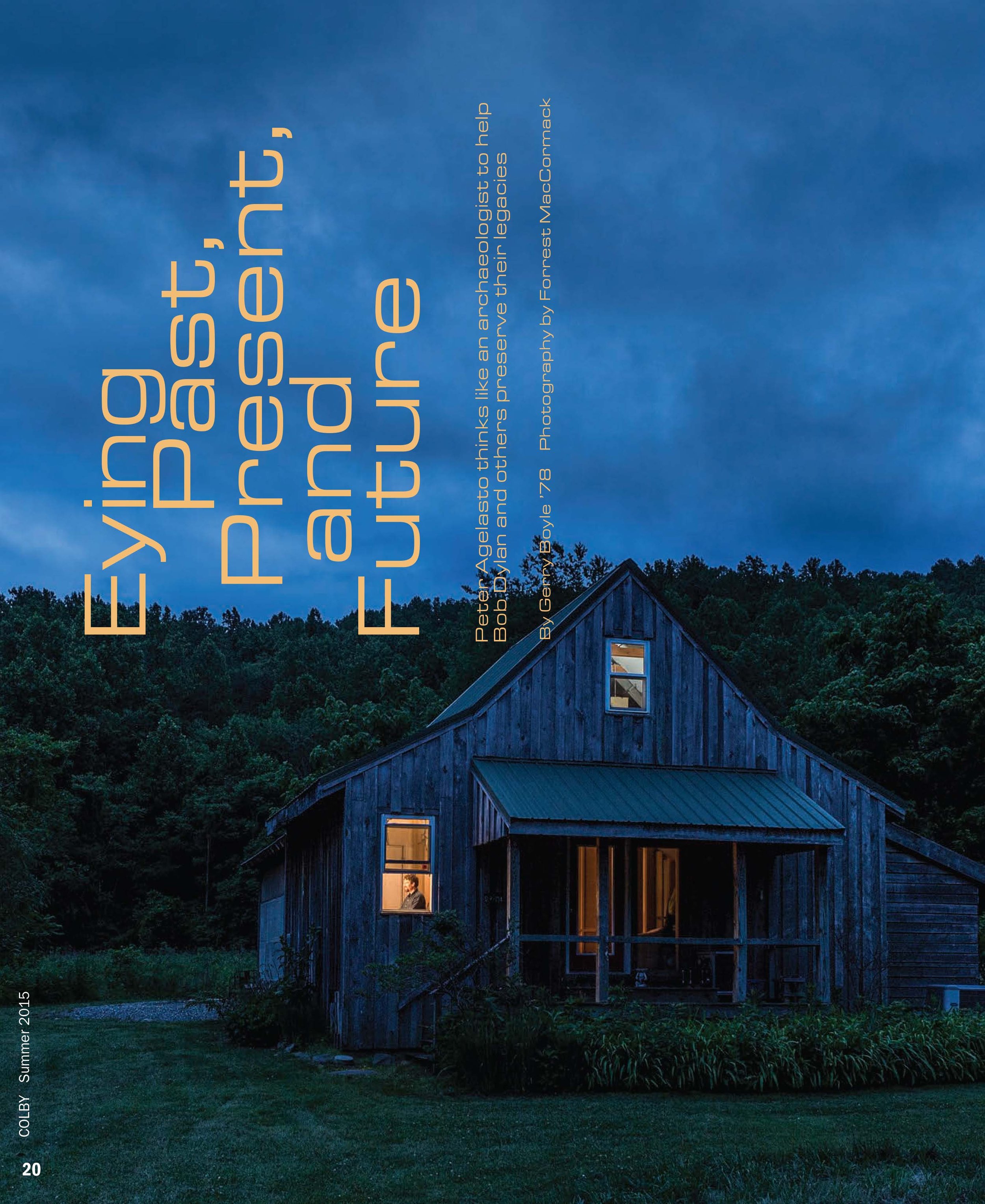 Nighttime photo of a rustic wooden house with illuminated windows, surrounded by trees and a cloudy sky.