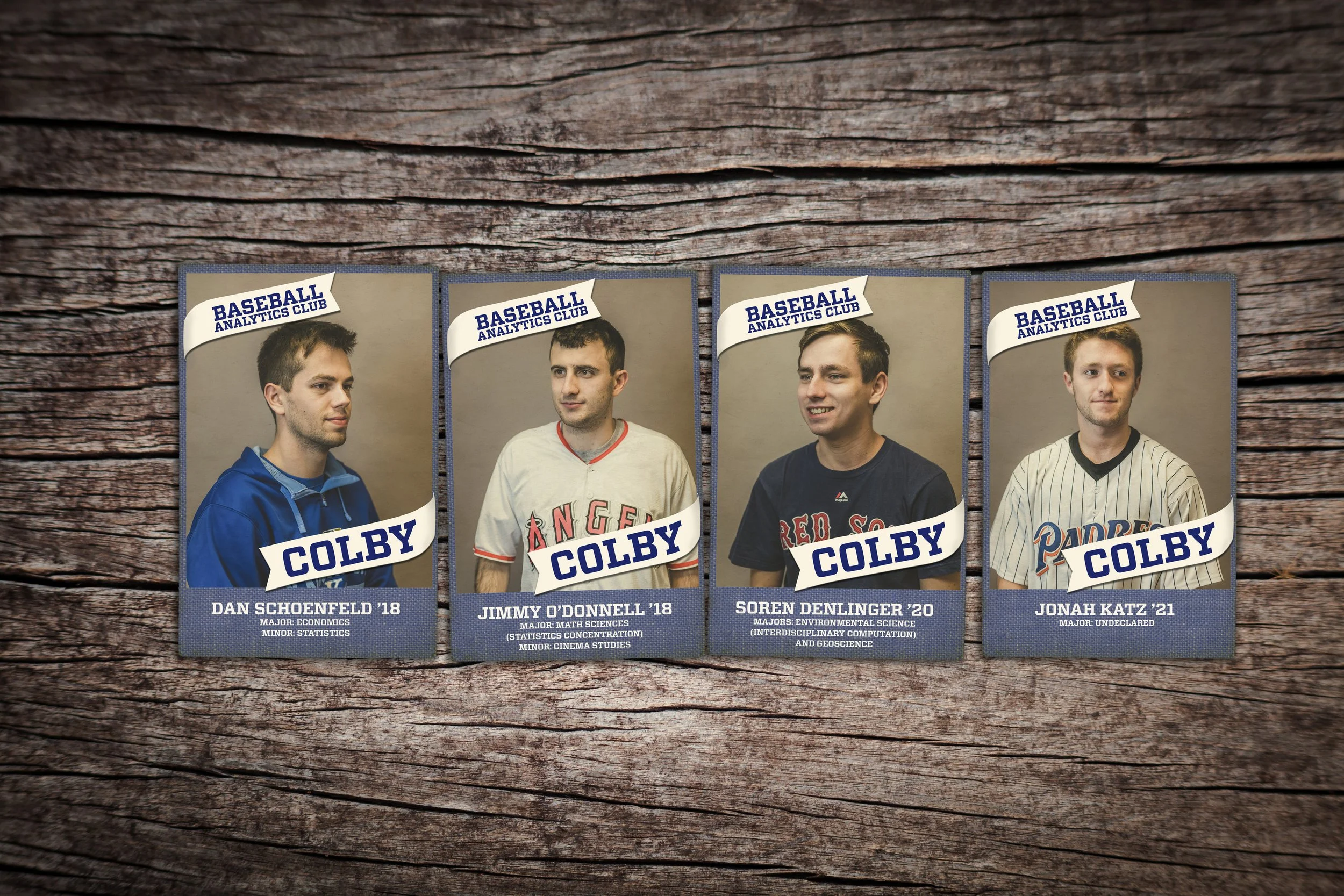 Four baseball trading cards featuring young men from the Baseball Analytics Club, each with their name, graduation year, major and minor area of study, on a wooden background.
