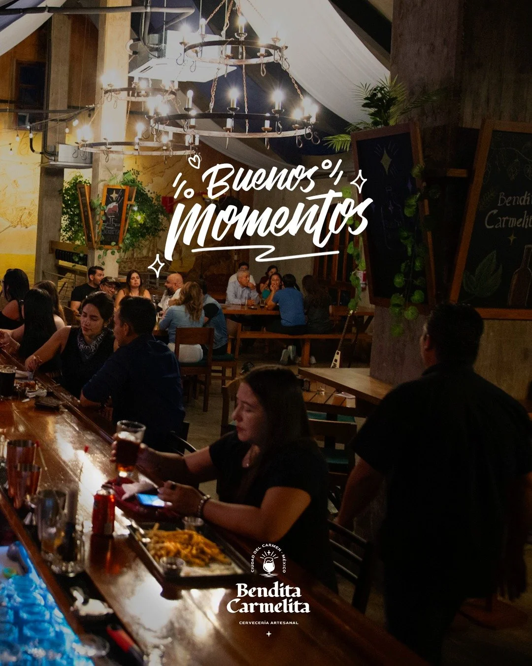 People dining at a restaurant with rustic wooden decor, chandeliers, and blackboards, with the overlay text '¡Buenos Momentos!' and a logo for Bendita Carmelita.