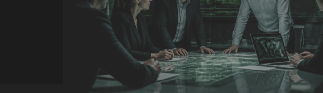 A group of professionals in business attire collaborating around a glass table with a digital map and a laptop.