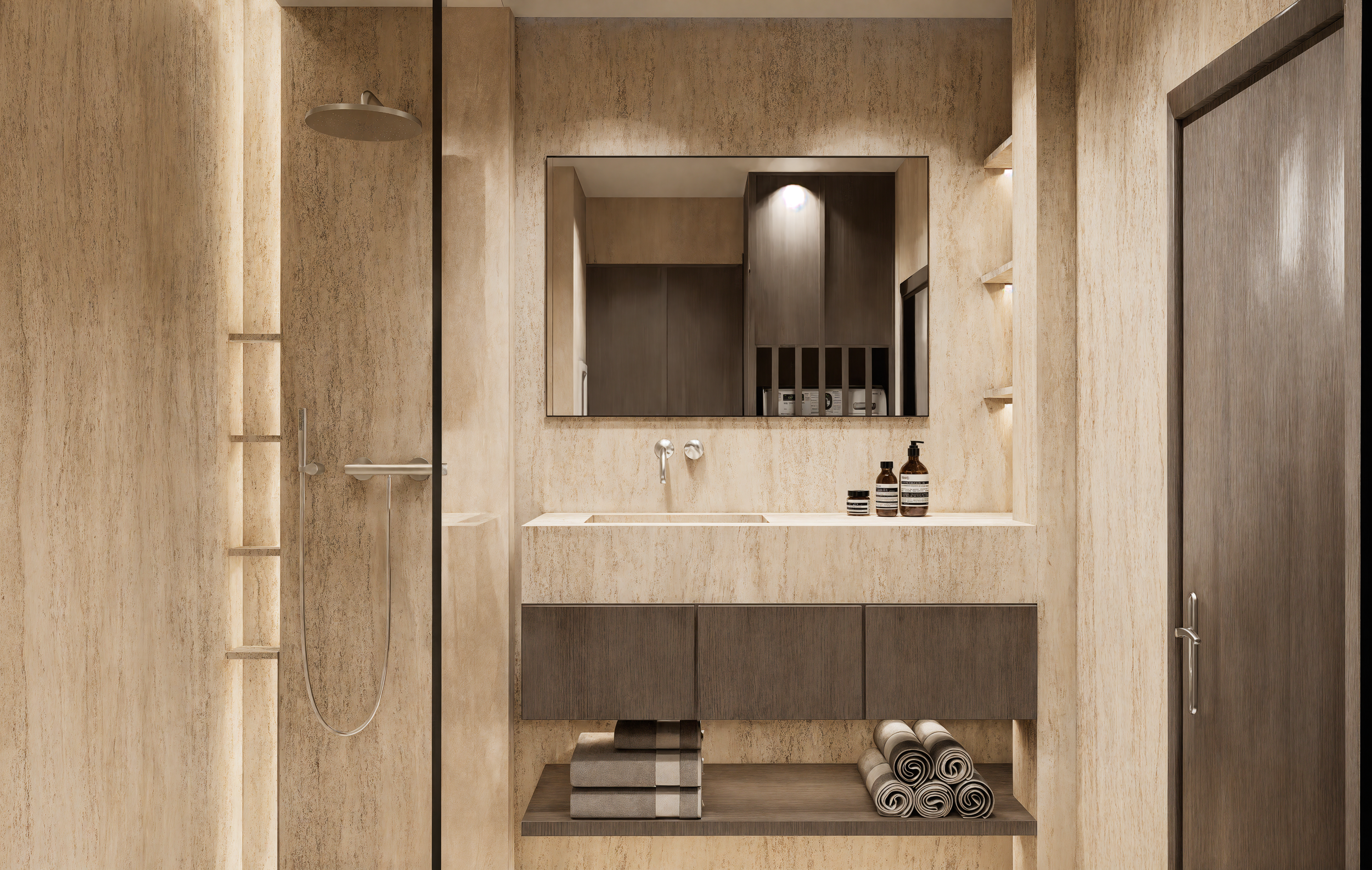 Modern bathroom with beige textured walls, a large mirror above a white vanity sink, and shelves on the sides. There is a shower area with a rain shower head on the left. Items on the vanity include brown bottles and containers. Towels are neatly rolled on the lower shelf.