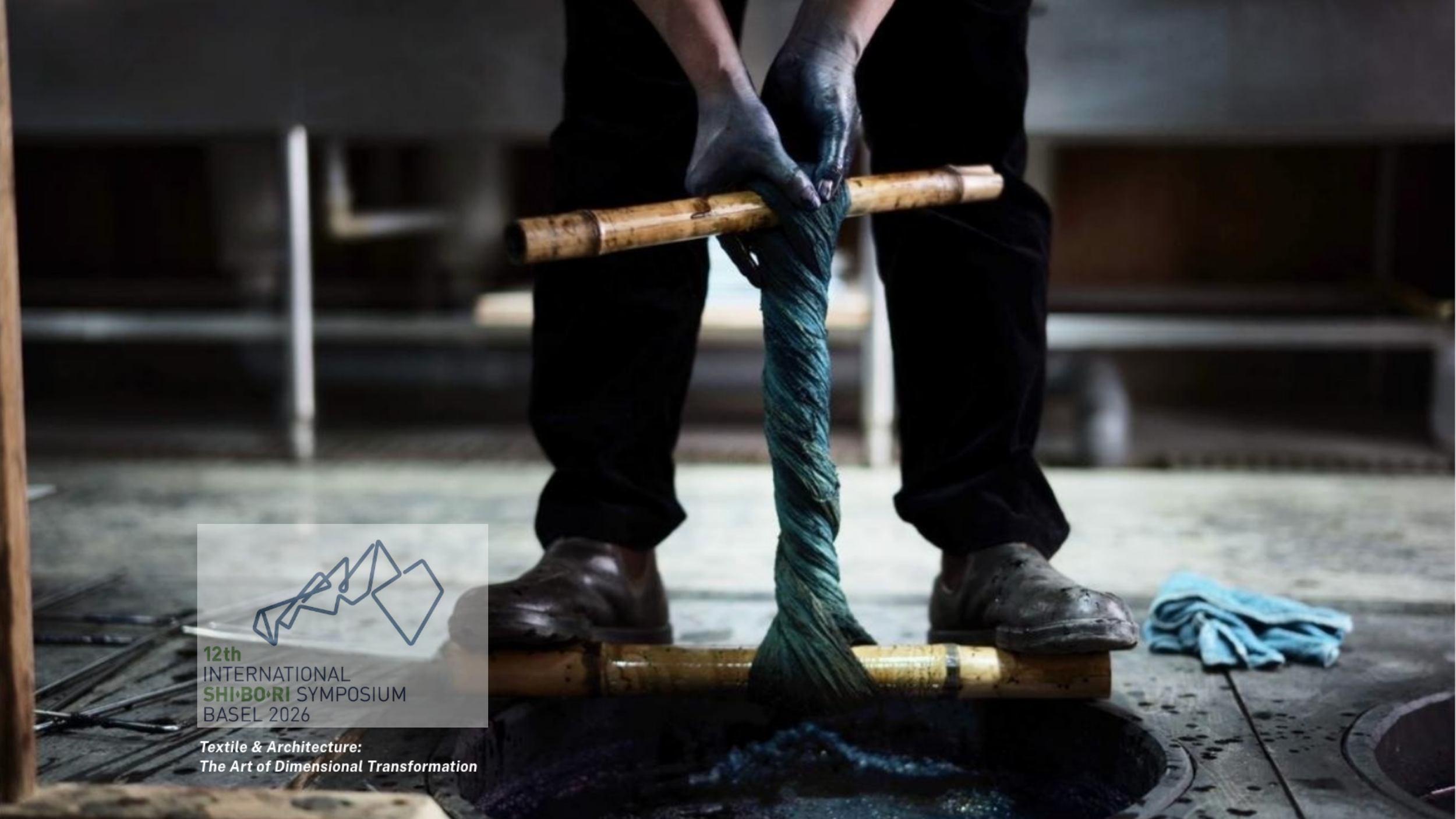 Japanese artisan wringing bound yarn and cloth over an indigo dye bath during the traditional shibori dyeing process in Japan.
