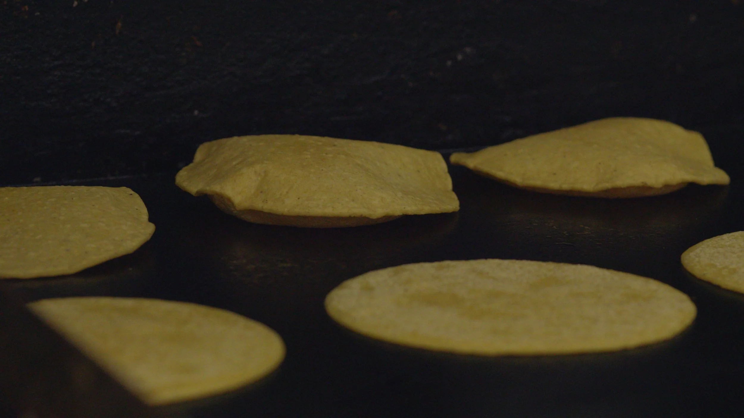 Nextamalized tortillas on the flat top cooking
