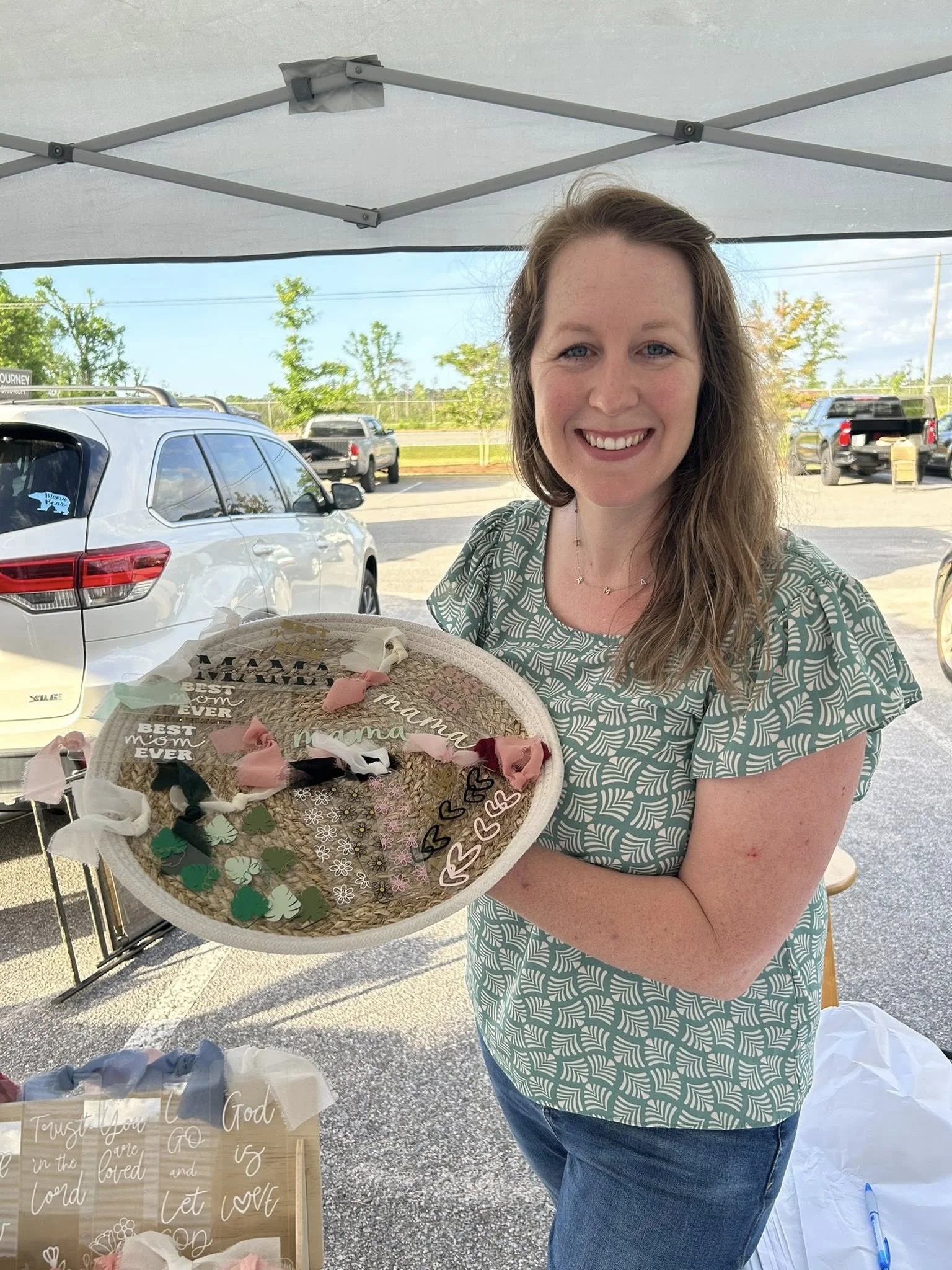 Woman smiling while holding a basket of custom acrylic bookmarks at an outdoor market.