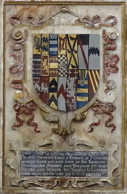 A shield with a heraldic coat of arms, surrounded by ornate carved decorations, with a memorial plaque below describing the Dyle family.