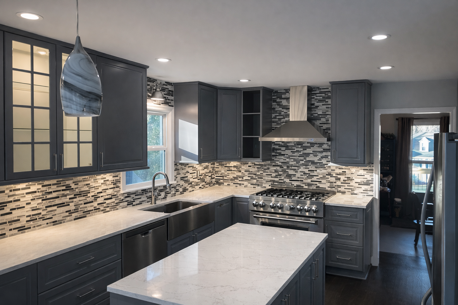 Modern kitchen with gray cabinets, white quartz countertops, a mosaic tile backsplash, stainless steel appliances, and a marble pendant light.