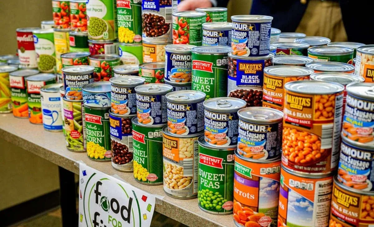 A well-stocked pantry with shelves of canned goods, dry foods, jars, and other stored ingredients.