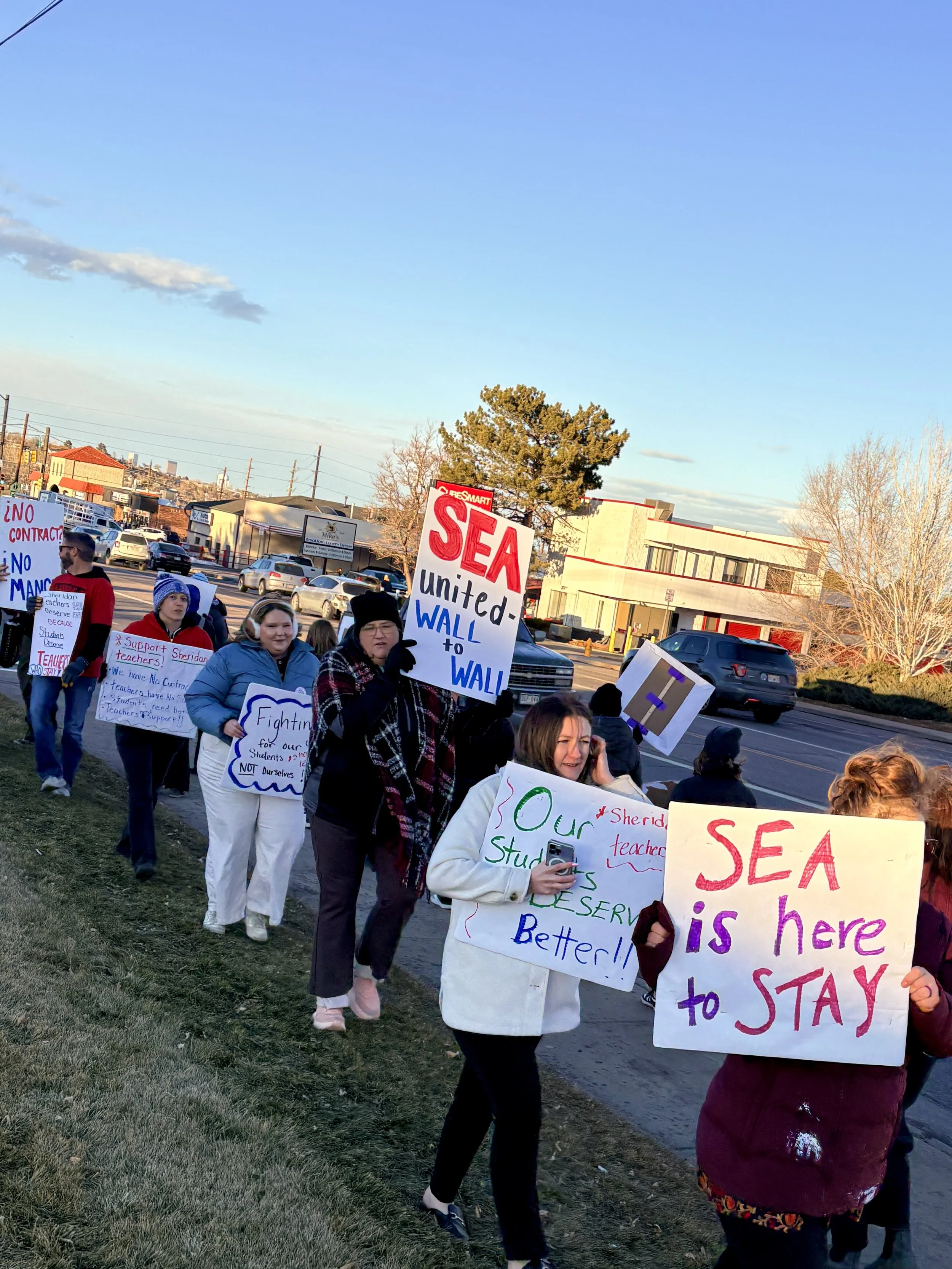 people holding picket signs reading SEA is here to stay, SEA untied wall to wall, our students deserve better, fighting for our students, support sheridan teachers