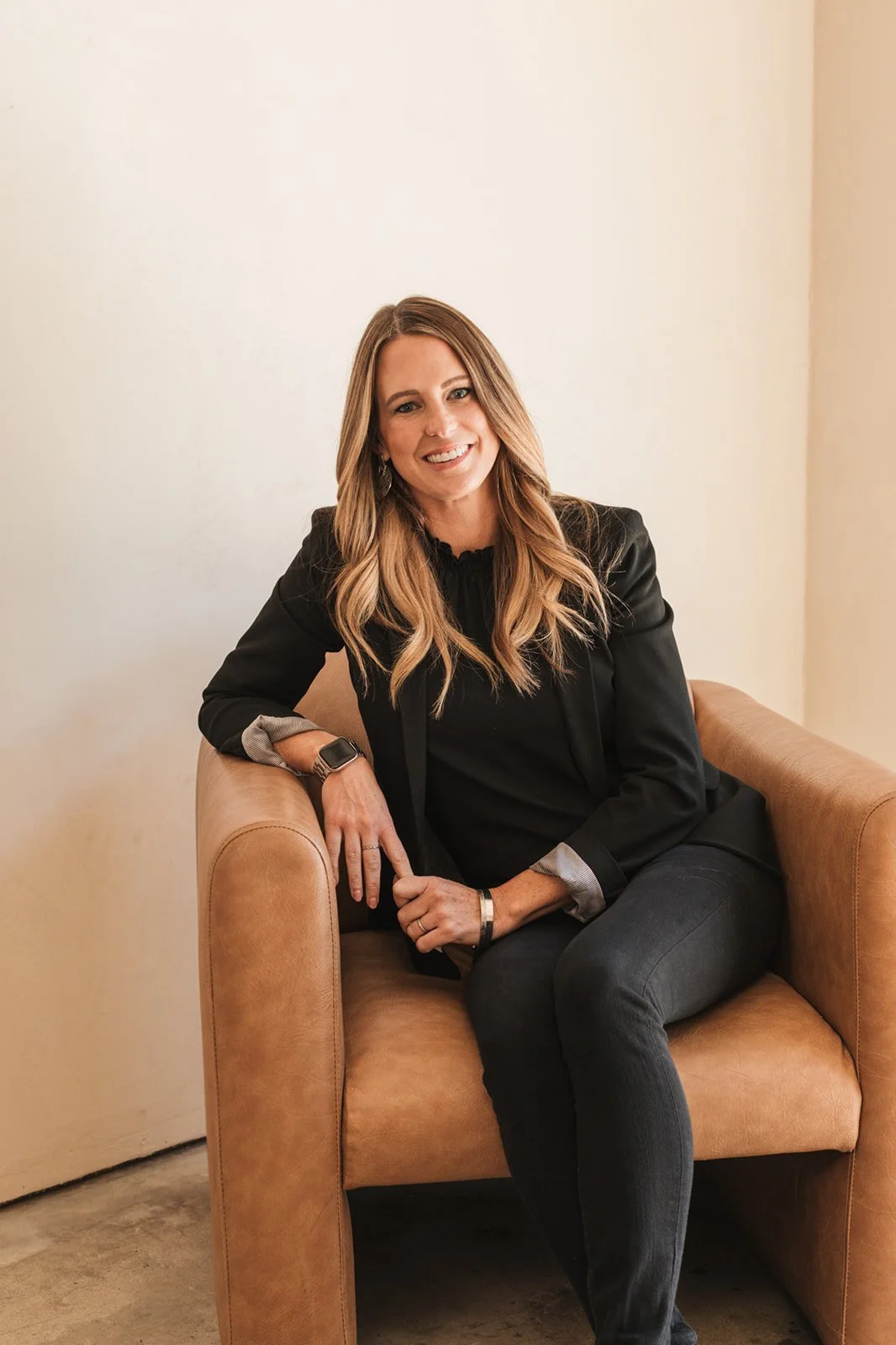 Kate Hendrickson, San Luis Obispo real estate agent, seated in a chair smiling.