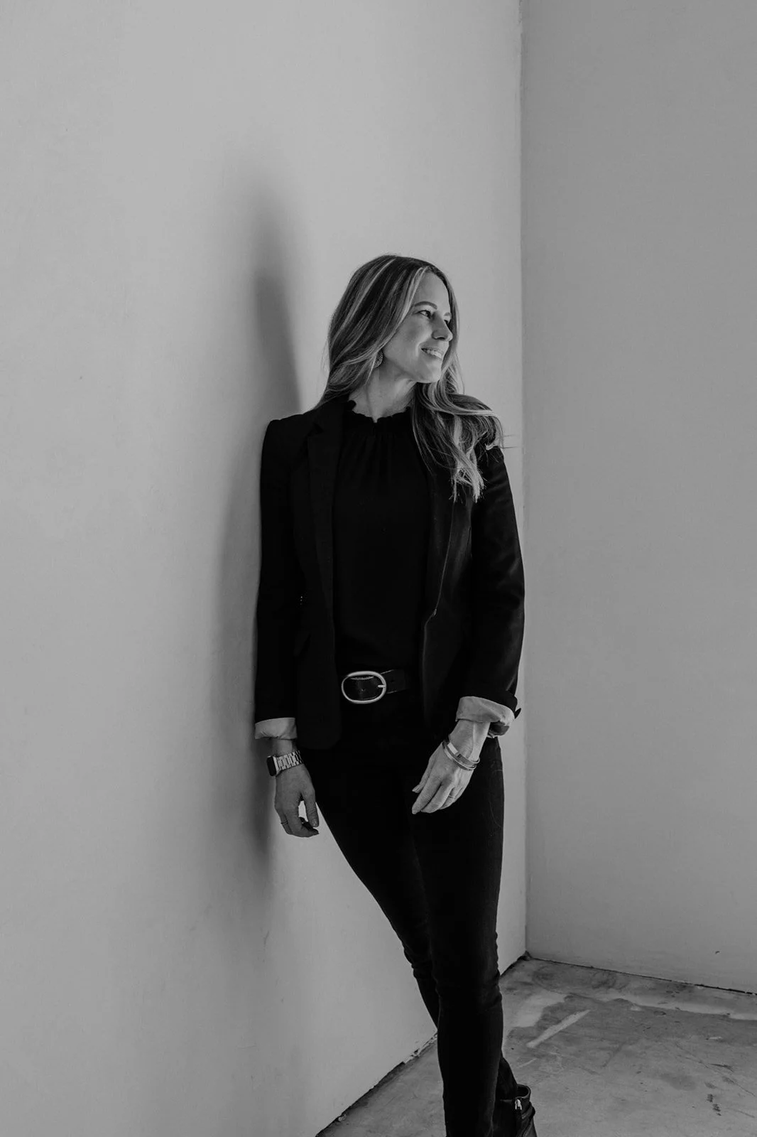 Kate Hendrickson, San Luis Obispo real estate agent, standing against a wall in black and white portrait.