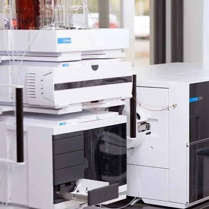 Laboratory equipment including a centrifuge, a gas chromatograph, and other analytical instruments inside a lab.