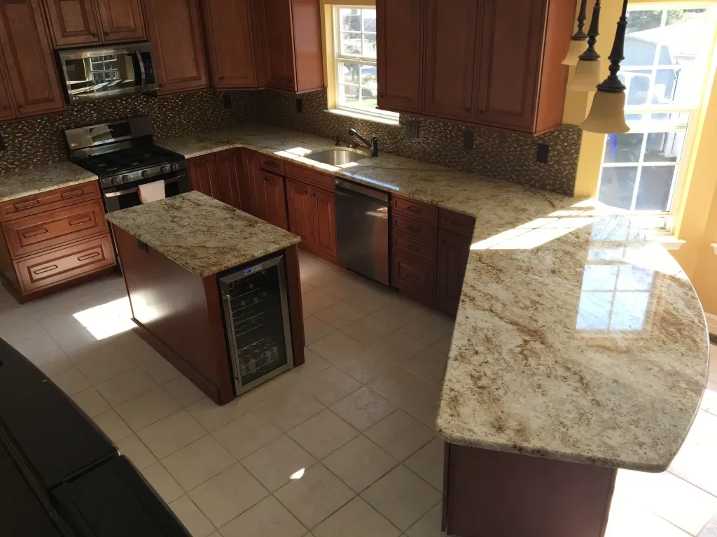 Kitchen with granite countertops, wooden cabinets, stainless steel appliances, and a small wine refrigerator on an island.