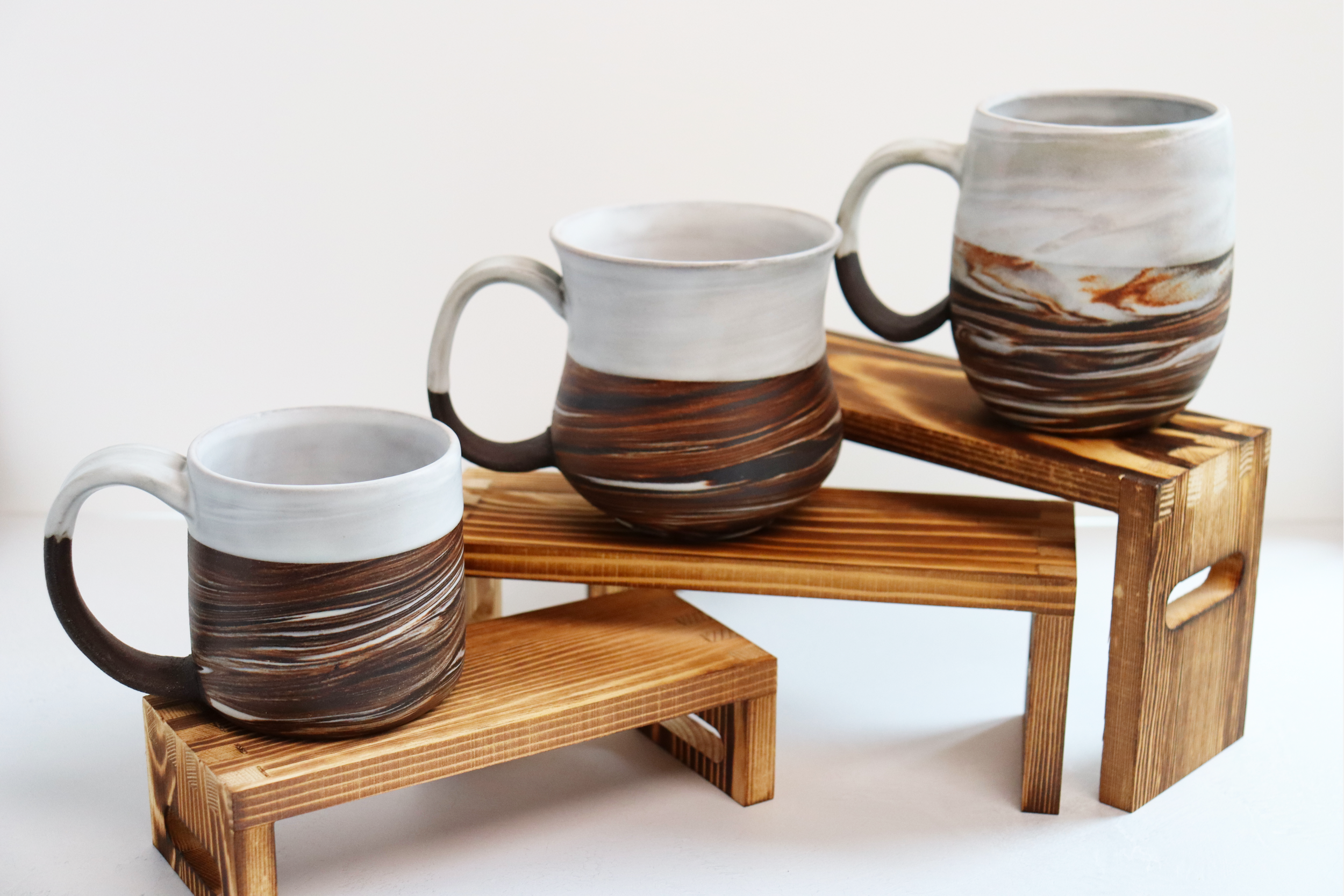 Dark brown stoneware and porcelain marbled mugs with satin white glaze