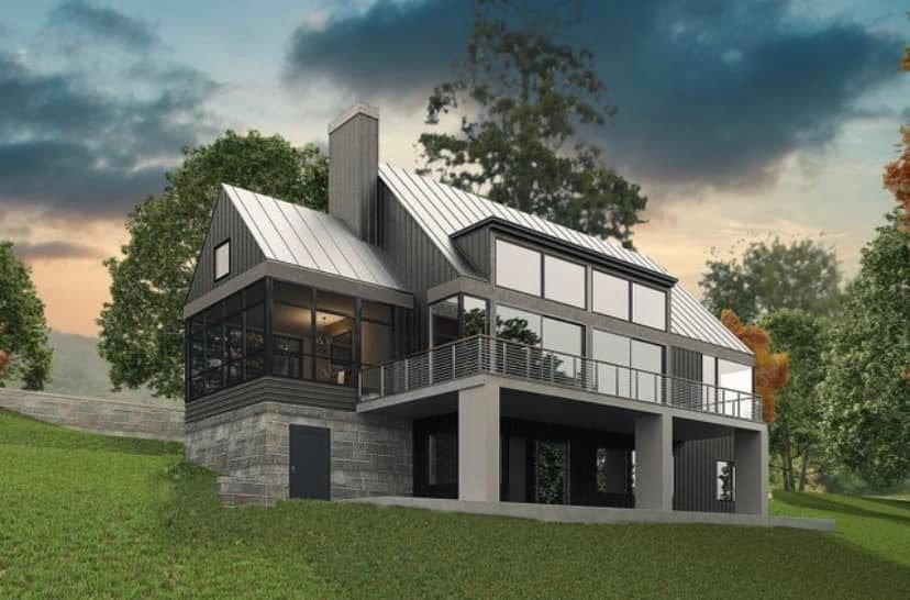 Modern house with metal roof and large windows, situated on a grassy hillside with trees in the background.