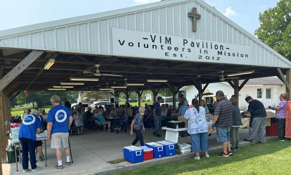 People gathered at VIM Pavilion, a volunteer organization in Mission established in 2012, serving food and socializing outdoors.