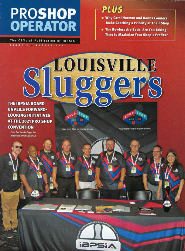Cover of PROSHOP OPERATOR magazine, August 2021 issue, featuring a group of people at the IBPSA booth with a table, posters, and a banner with logos, promoting the Louisville Sluggers event and related initiatives.