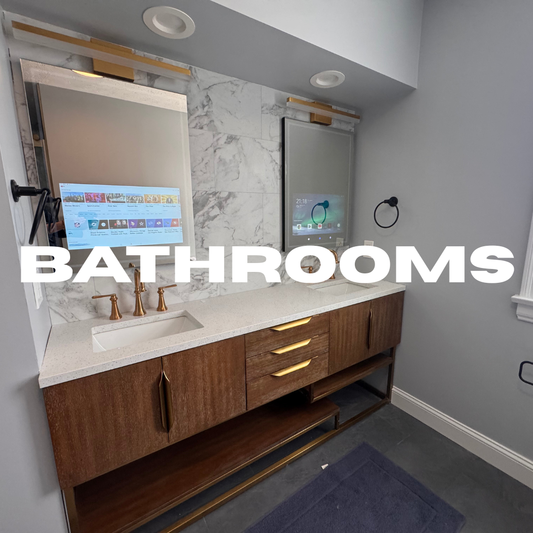Modern bathroom vanity with white countertop, marble backsplash, gold fixtures, wooden cabinet, mirror, and smart mirror with display screen, gray walls, black towel ring, and dark floor mat.