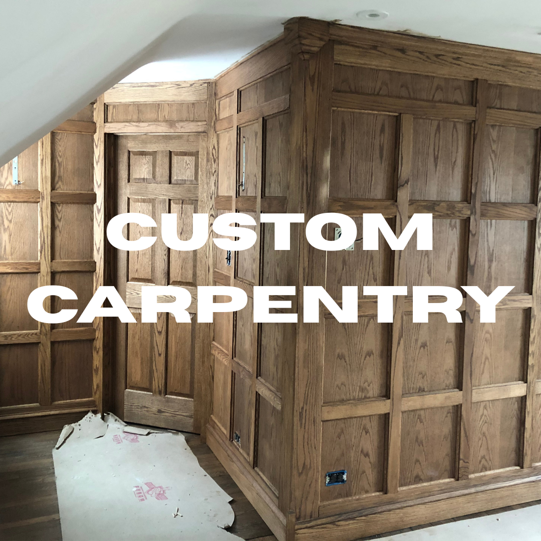 Interior of a room with custom oak wood carpentry on the walls and cabinetry, under construction with unfinished electrical outlets and a torn piece of protective film on the floor.