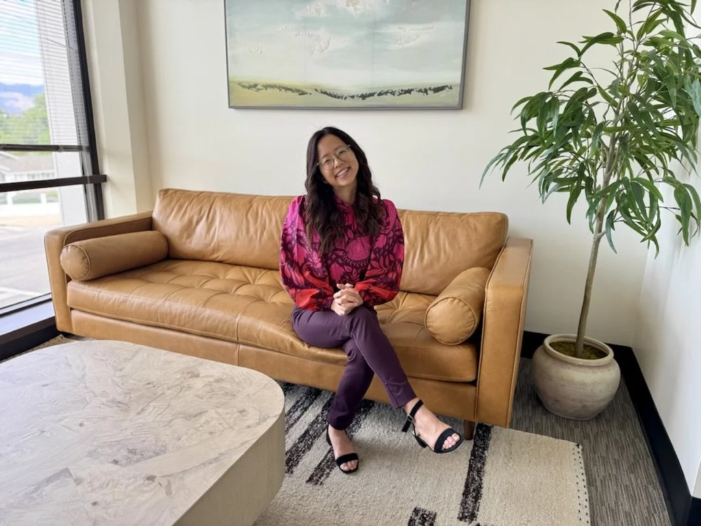 Therapist Ingrid Nishimoto sitting on a couch in her Granada Hills therapy office