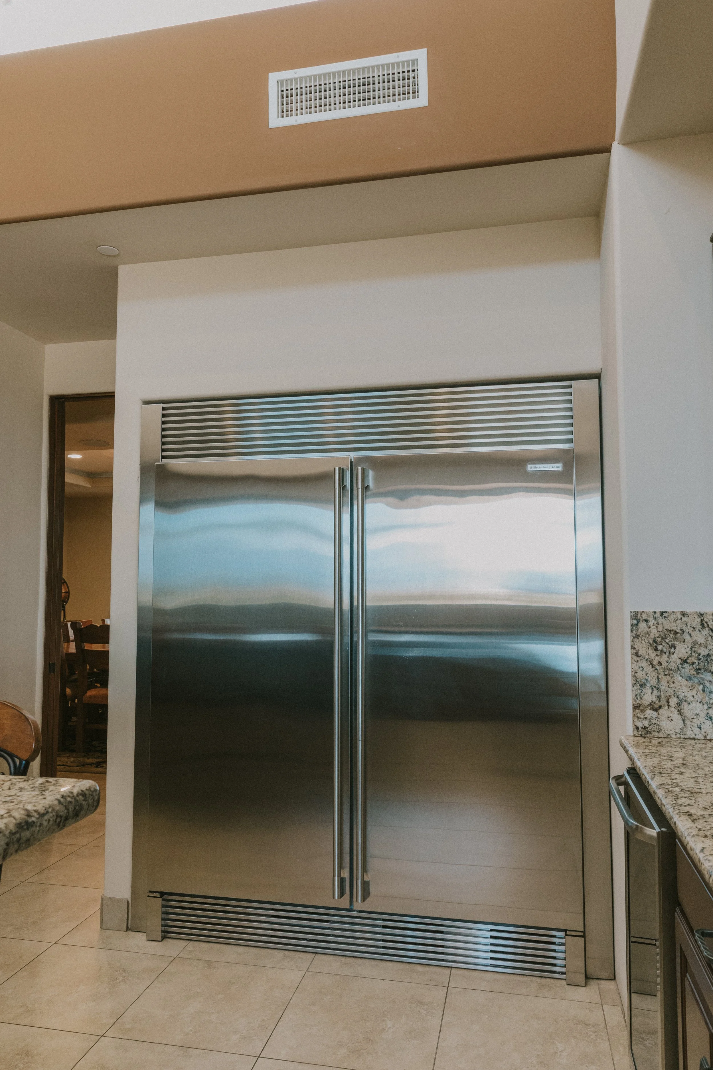 Stainless steel commercial refrigerator with double doors in a kitchen or break room.