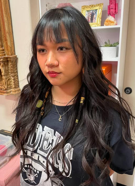 woman with healthy long black hair styled with long layers and 2 dreadlock pieces at BombChelle Hair studio