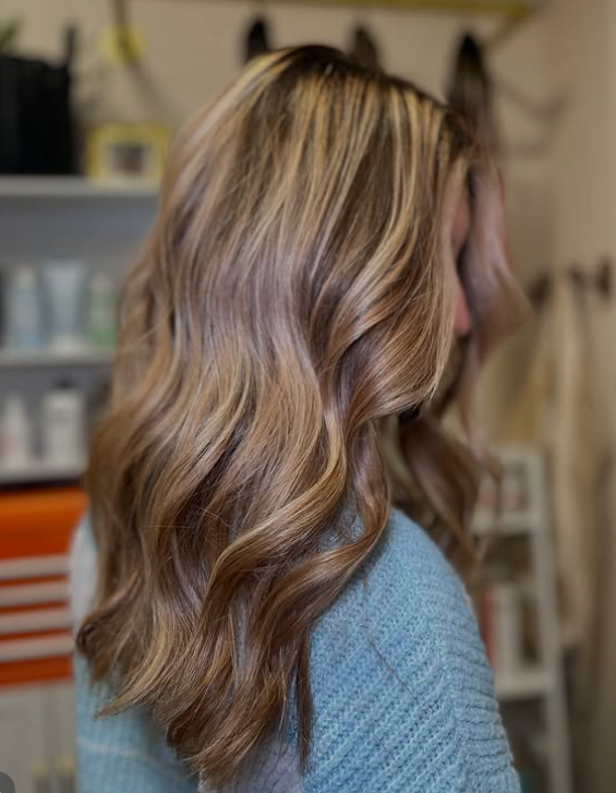 Woman with healthy and shiny blonde, color corrected hair in BombhCelle Hair studio