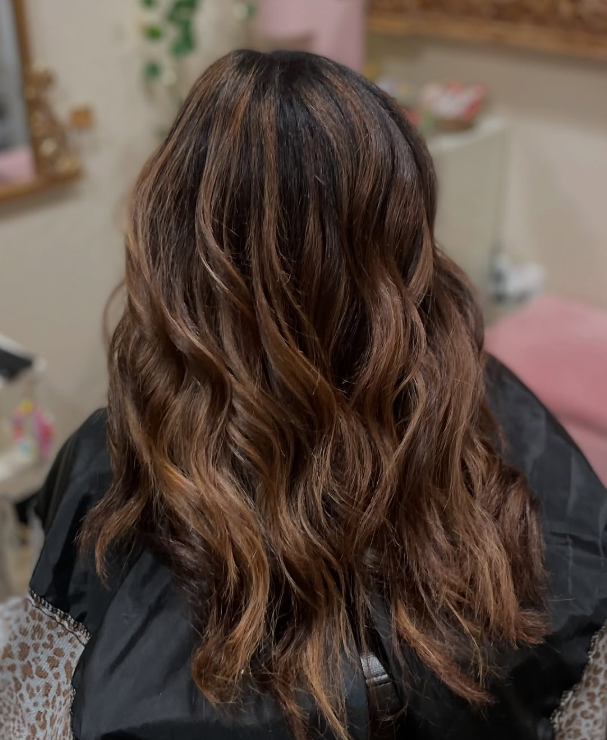 Woman with healthy and shiny brunette balayage from BombChelle Hair studio
