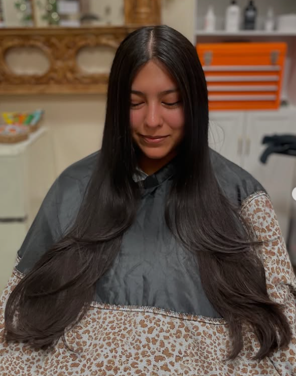 Woman with healthy and shiny  long dark black hair and long layers sitting in bombchelle hair studio