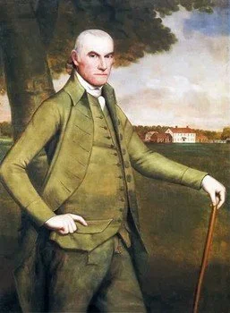 Portrait of a man in 19th-century clothing standing outdoors with a cane, trees, and a building in the background.