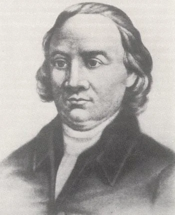Black-and-white portrait of a man with shoulder-length hair, wearing a high-collared shirt and a dark coat.