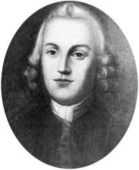 Black and white portrait of a young man with shoulder-length curly hair, wearing a dark coat and a white shirt.
