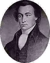 Black and white portrait of a man from the 19th century wearing a dark coat and a high-collared shirt.