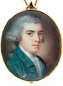 Oval portrait of a young man with dark, curly hair wearing a greenish-blue jacket and a white shirt with a high collar