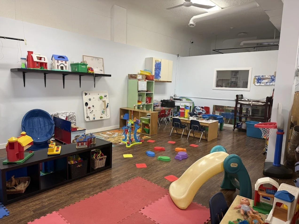 Toddler classroom with open play areas and age appropriate toys in a bright daycare environment.