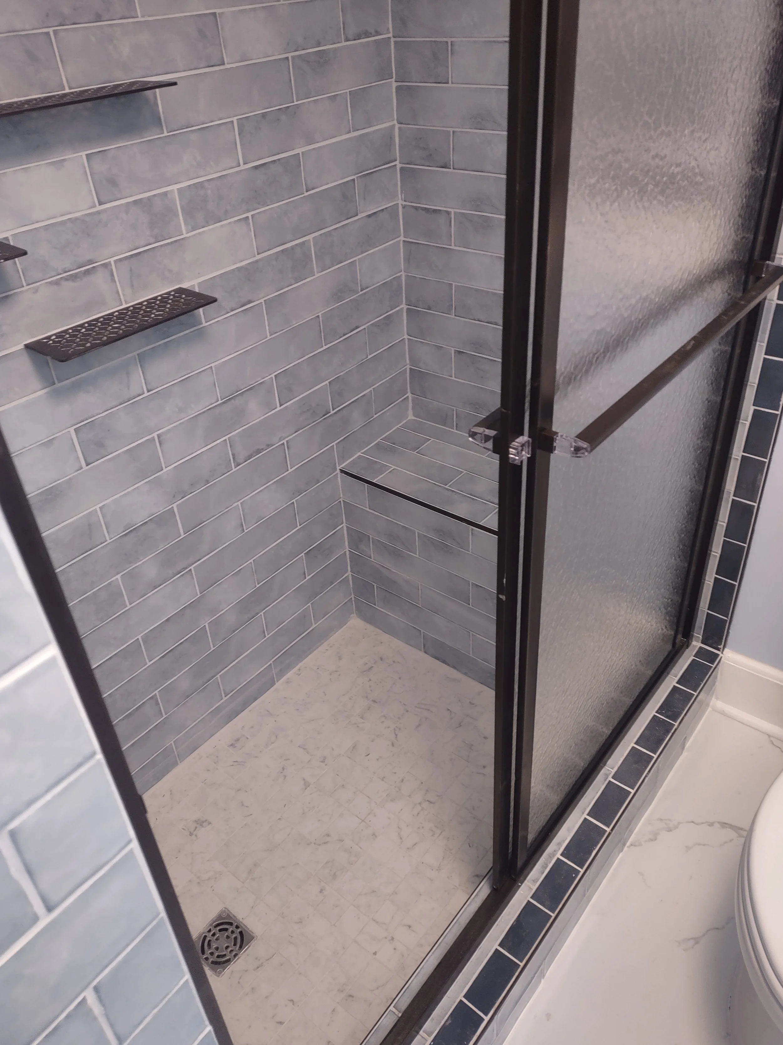 Shower tilework including custom bench.