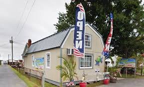 Small building with patriotic flags and banners, surrounded by trees and a grassy area.