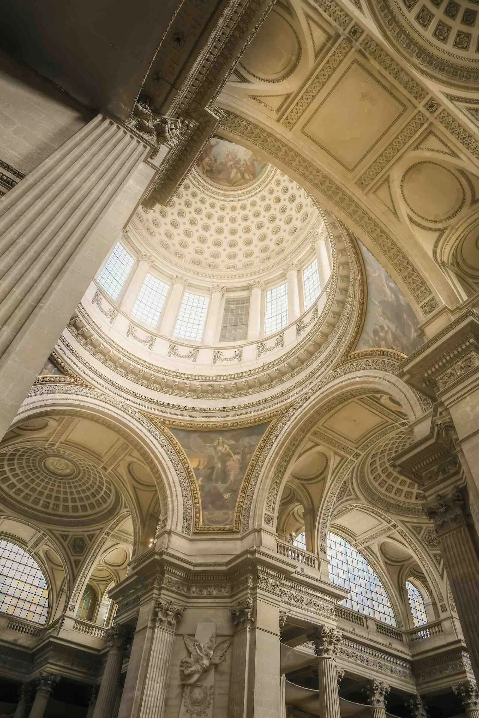 Interior view of a grand, ornate building with a domed ceiling, large windows, and decorative architectural details.