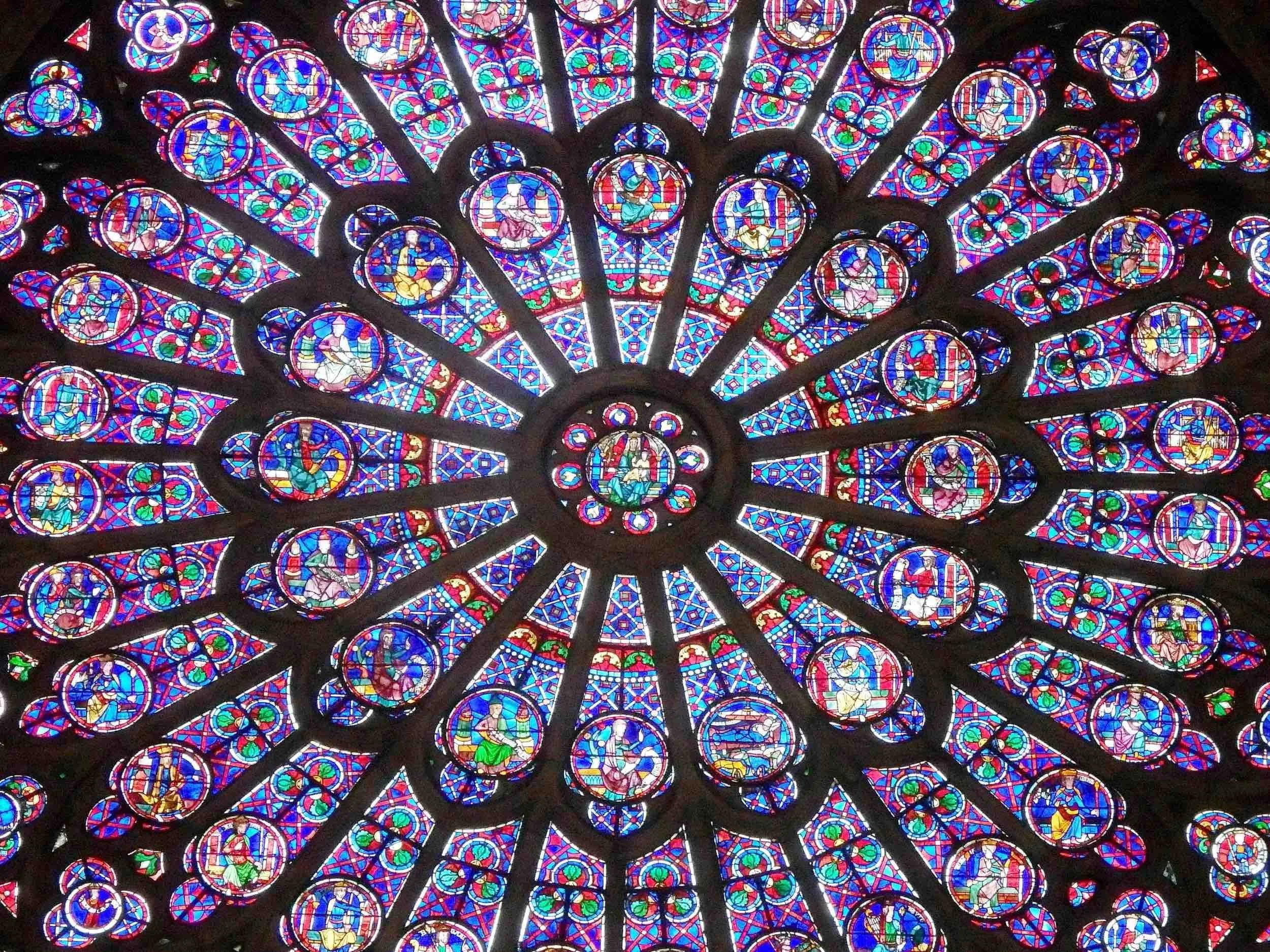 Colorful stained glass ceiling with intricate circular designs depicting religious figures and scenes.
